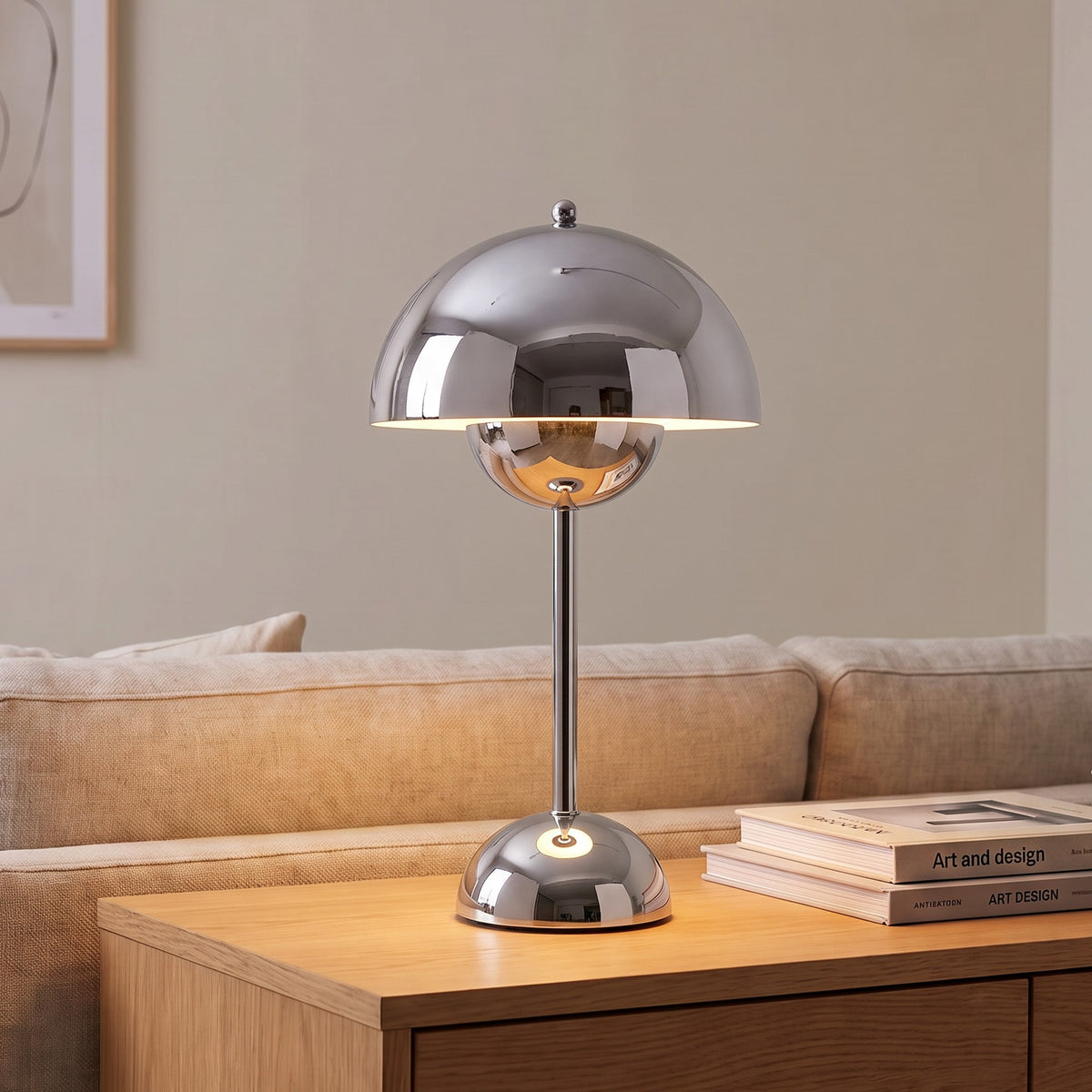 Oona table lamp in Chrome on a sideboard beside a sofa