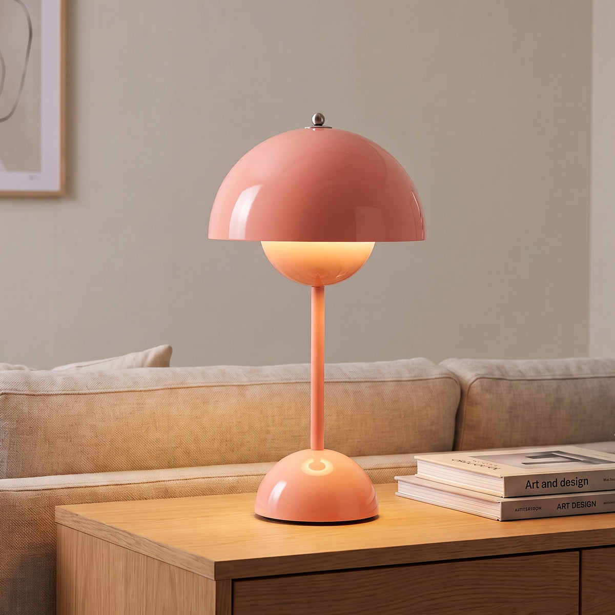Oona table lamp in Coral Pink on a sideboard beside a sofa
