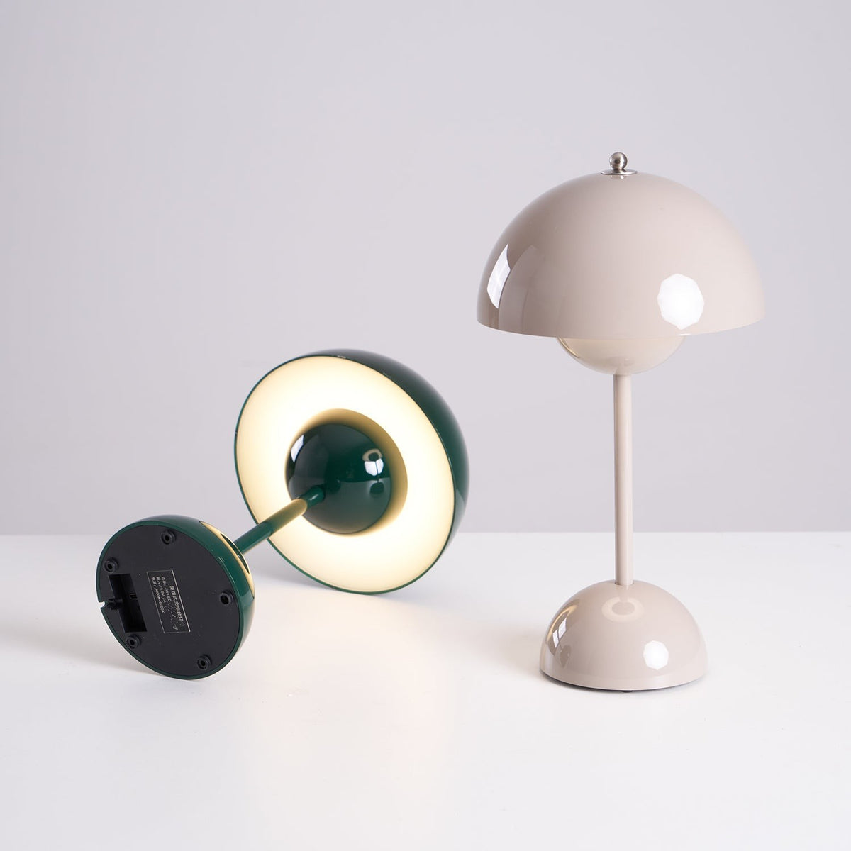 Oona table lamp tipped on its side beside an upright lamp, showing the base
