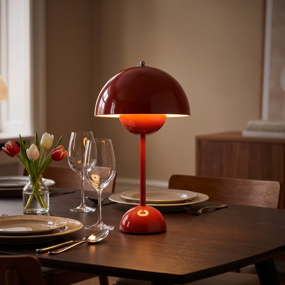 Oona table lamp in deep red on a dining table set for two in the evening