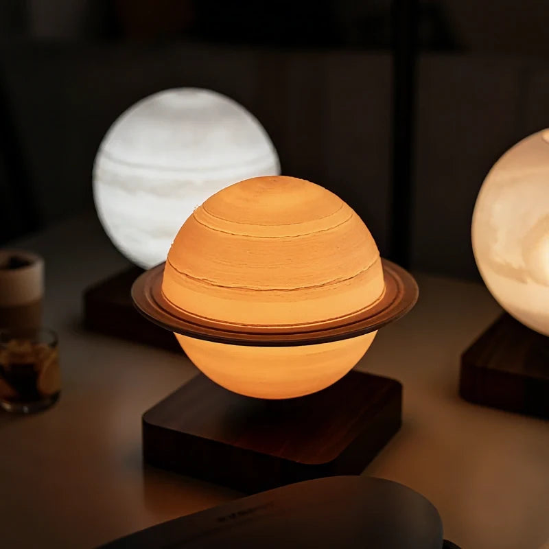 Orsa Saturn lamp floating above a walnut base