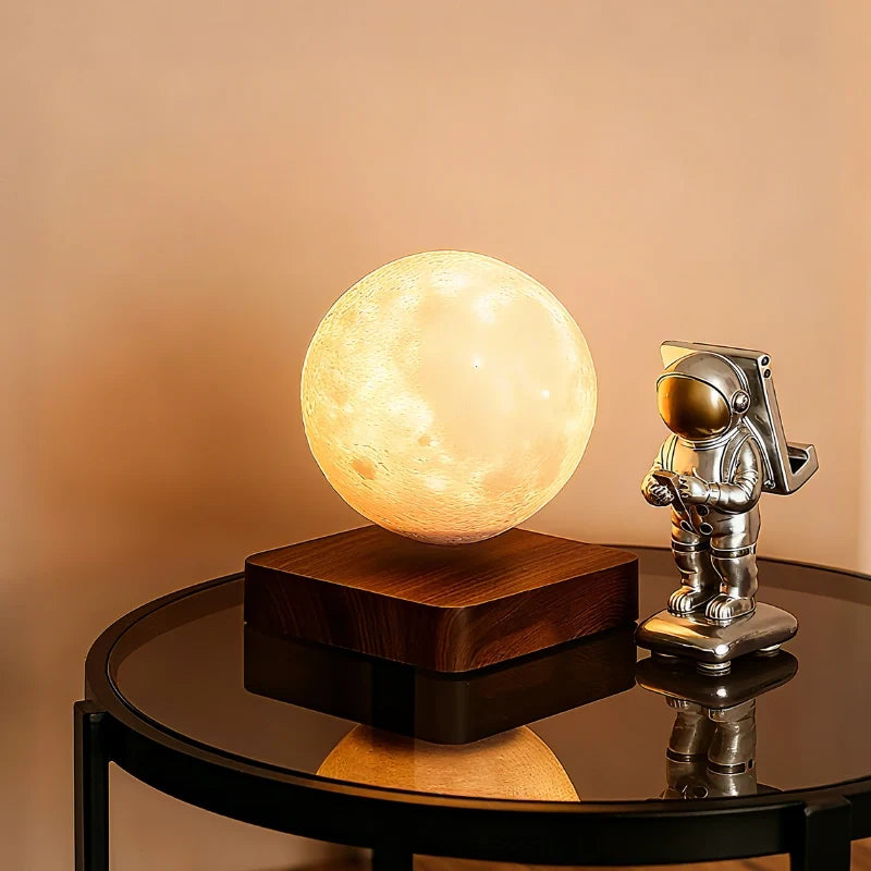 Orsa moon lamp floating above a walnut base on a glass table
