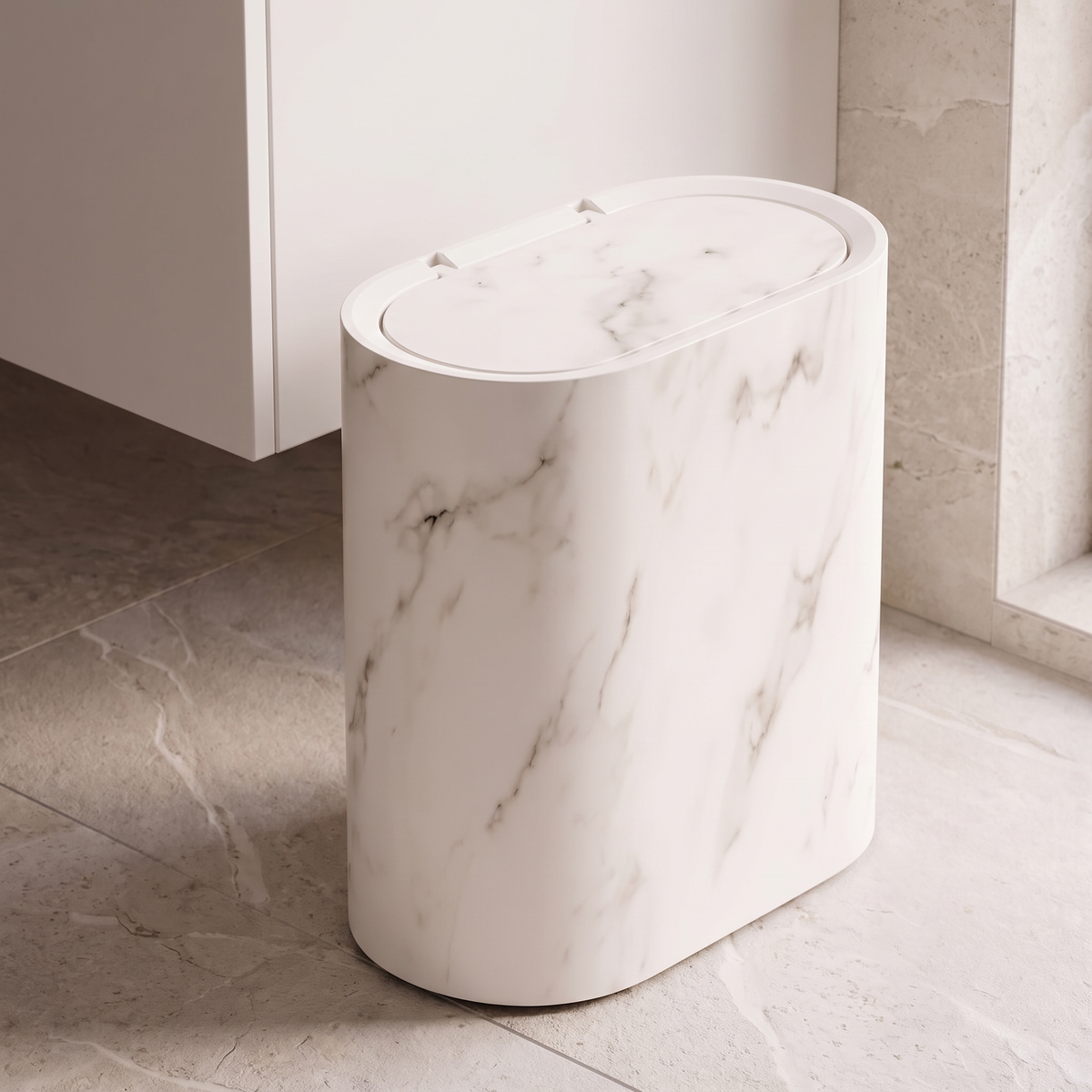 Oval waste bin in cream white marble beside a bathroom vanity