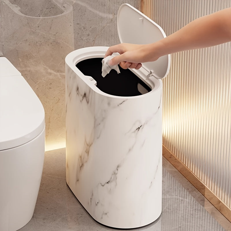 Hand dropping a tissue into the cream marble bin with the lid flipped up