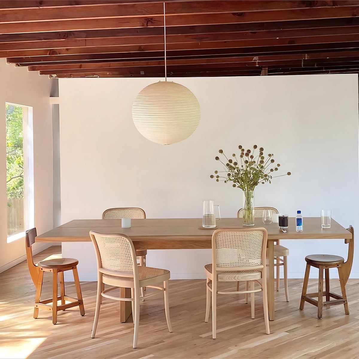Pia pendant light, white washi paper globe hanging over a long dining table