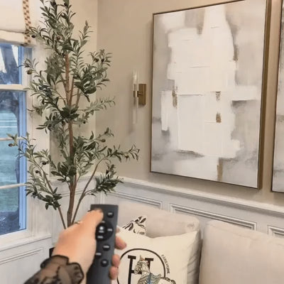 Namsos wall lights switched on by remote beside framed art