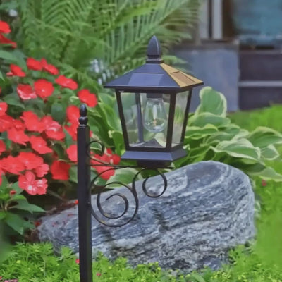 Askim solar lantern planter glowing in a garden bed