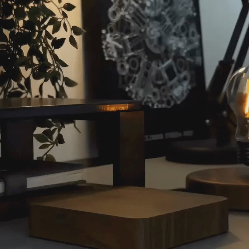 Orsa moon lamp floating and turning above its walnut base
