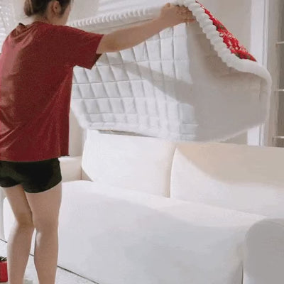 Clip of the holiday seat pad being laid along a sofa seat