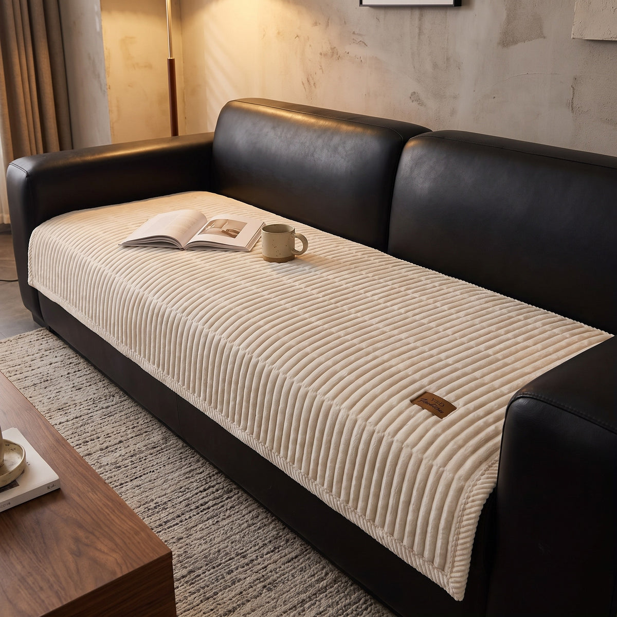 Quilted couch cover in cream on the seat of a sofa in a living room