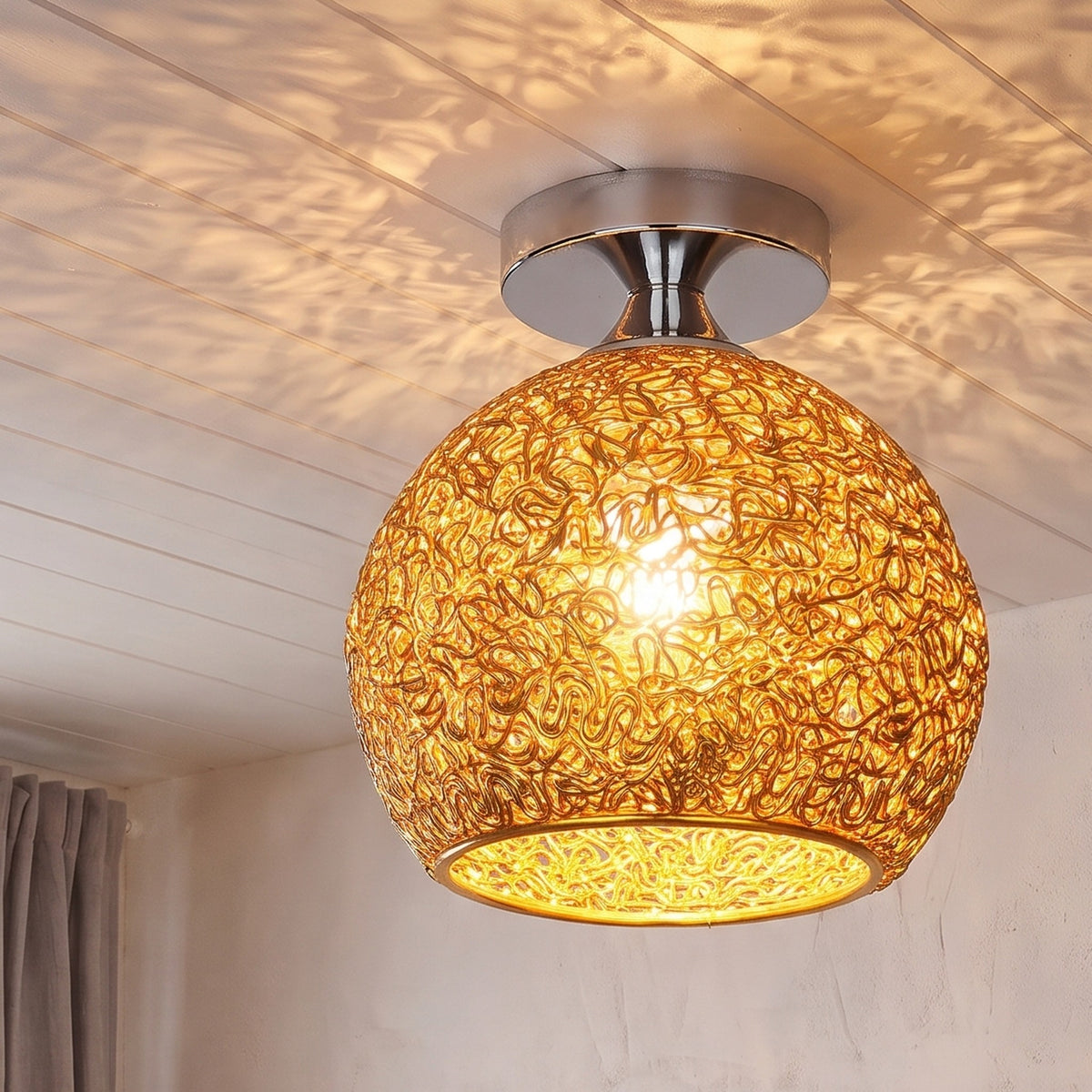 Gold Saara wire dome ceiling light lit in the same room
