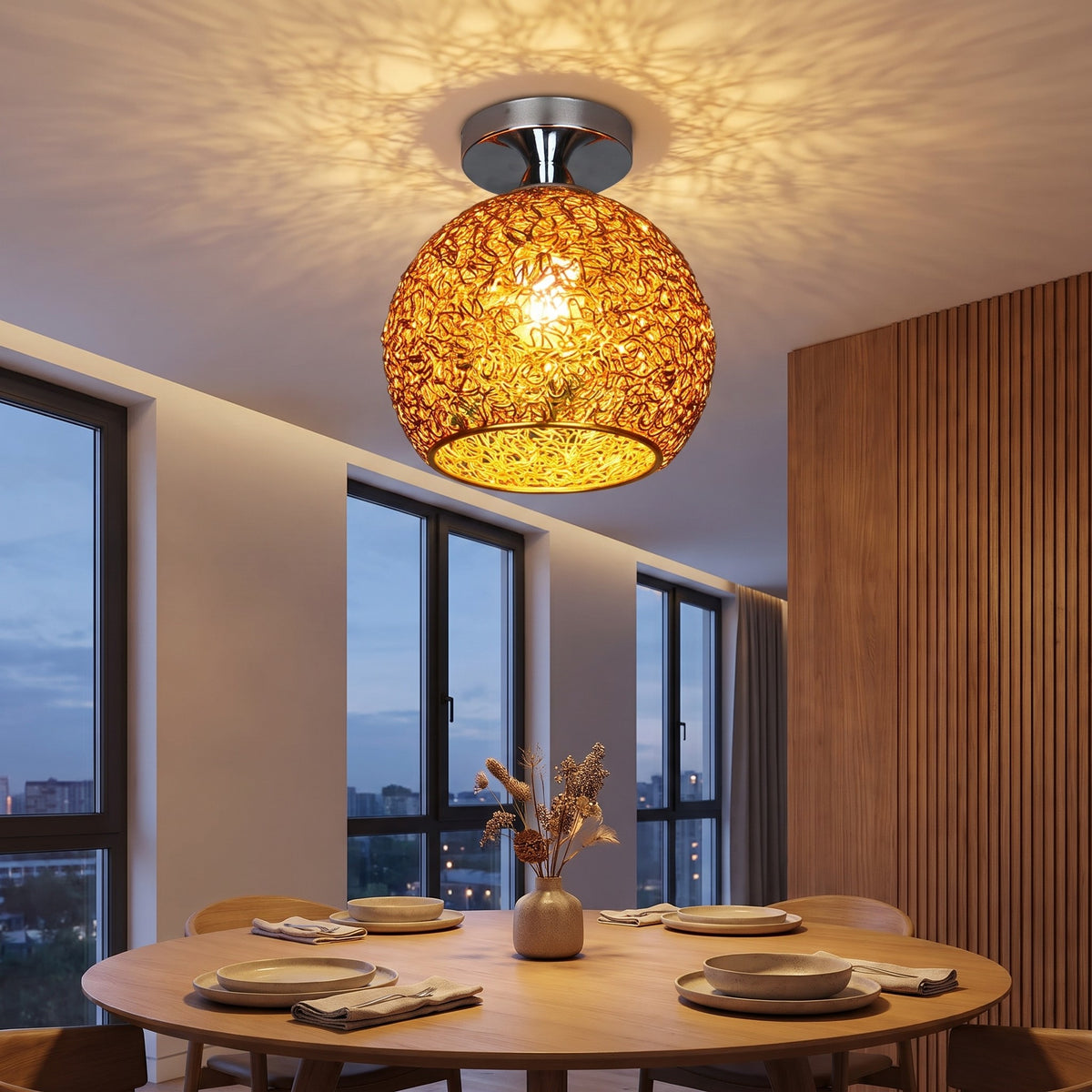 Gold Saara wire dome ceiling light lit above a dining table