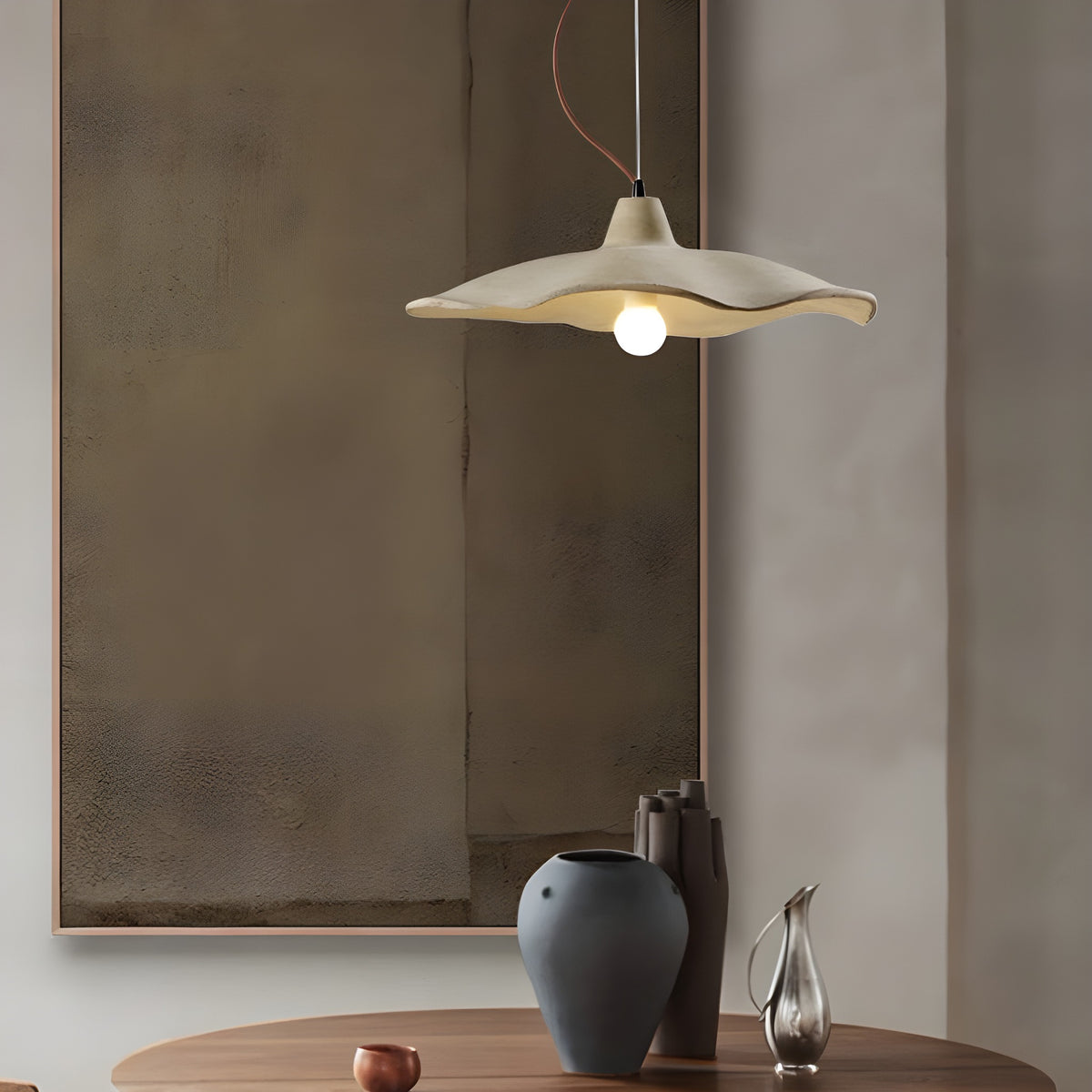 Sanna pendant light with wavy cement shade over a round dining table