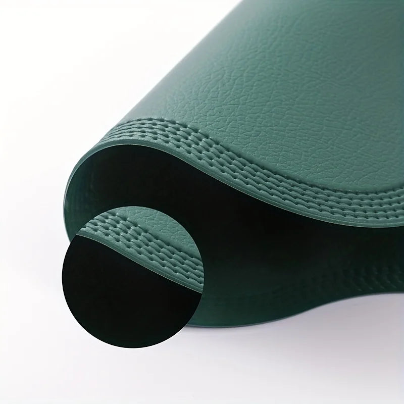 Close view of the faux leather grain and stitched border on a green placemat
