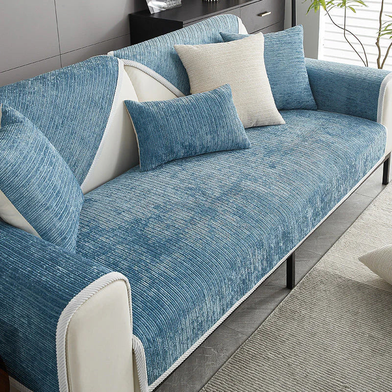 Blue ribbed sofa cover with pillows on a sofa