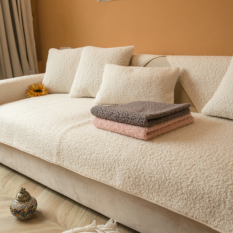 Off white sherpa sofa cover with folded throws on the seat
