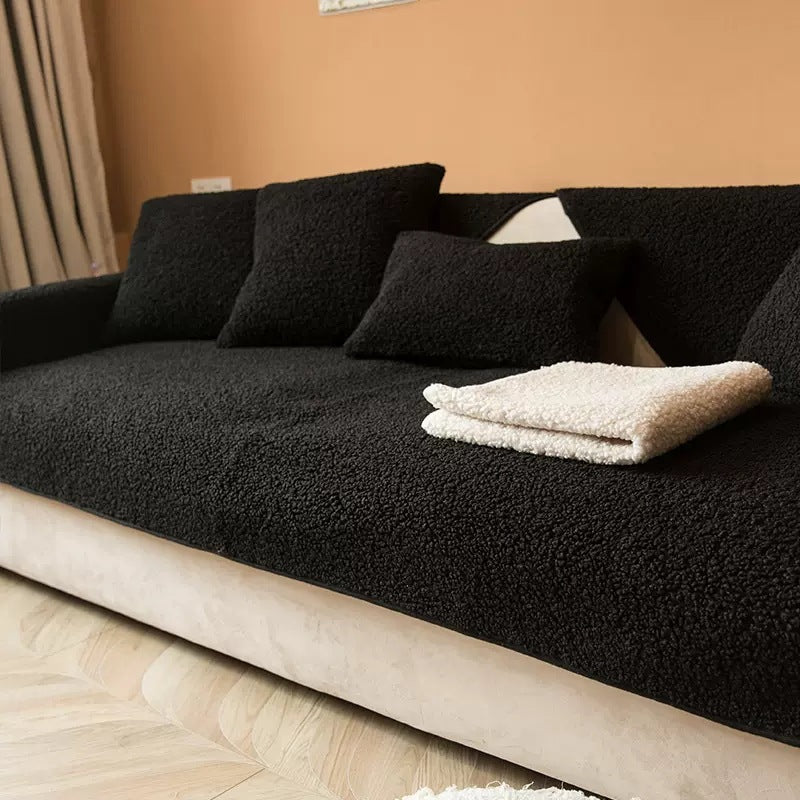Black sherpa sofa cover with a folded cream throw