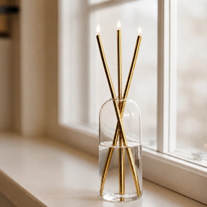 Skive gold oil candles on a sunny windowsill