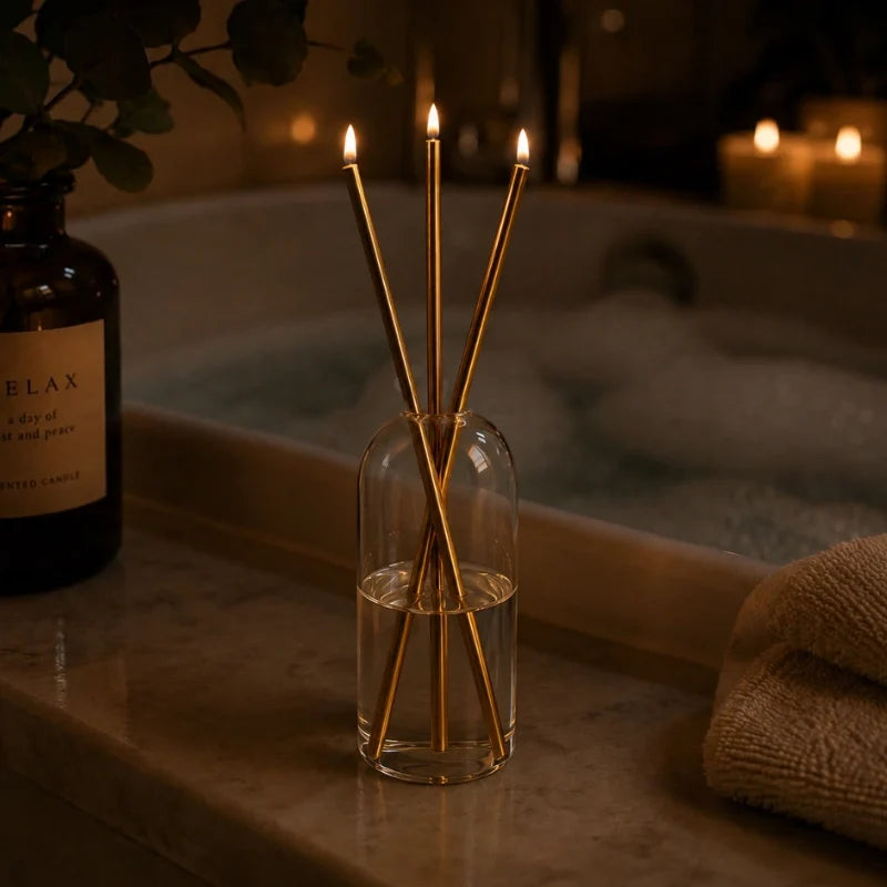 Skive gold oil candles lit on a bathroom counter