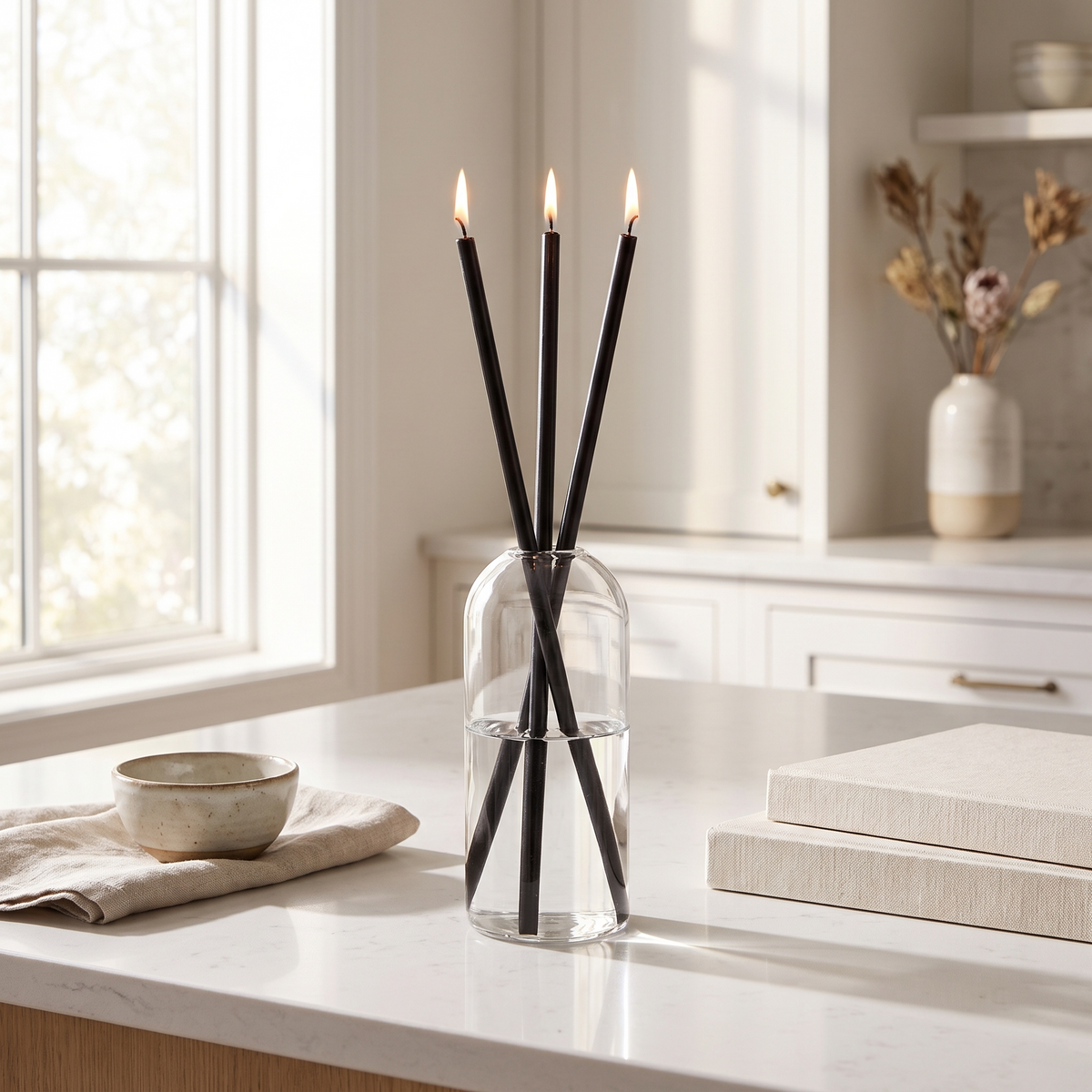 Skive oil candles in a clear glass vessel on a kitchen counter