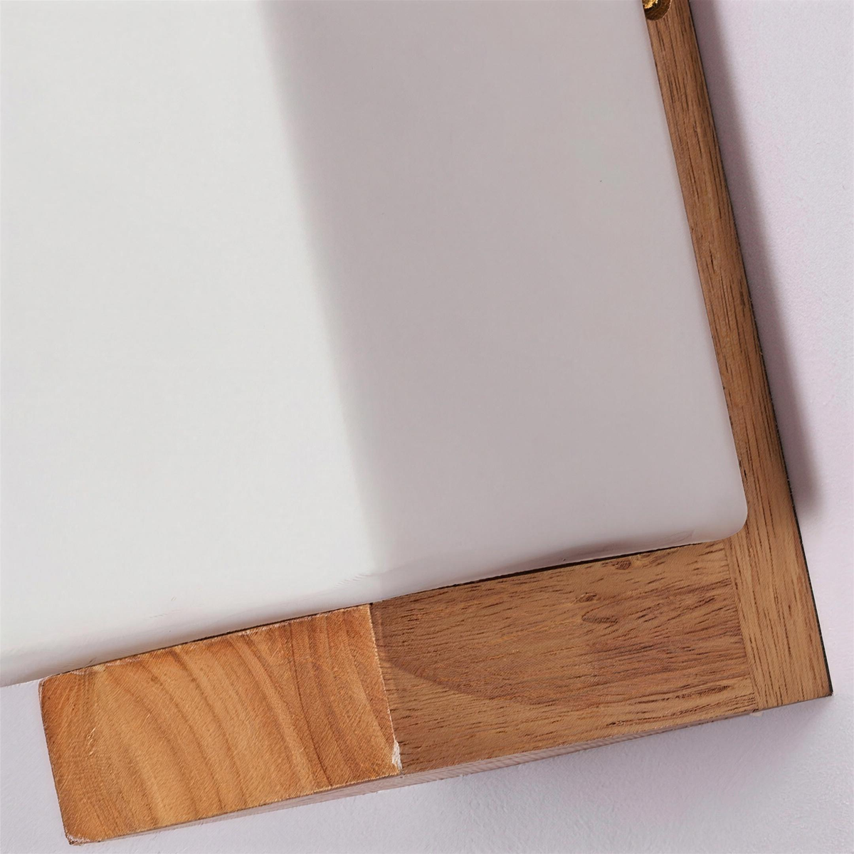 Close up of the wood ledge and white glass corner
