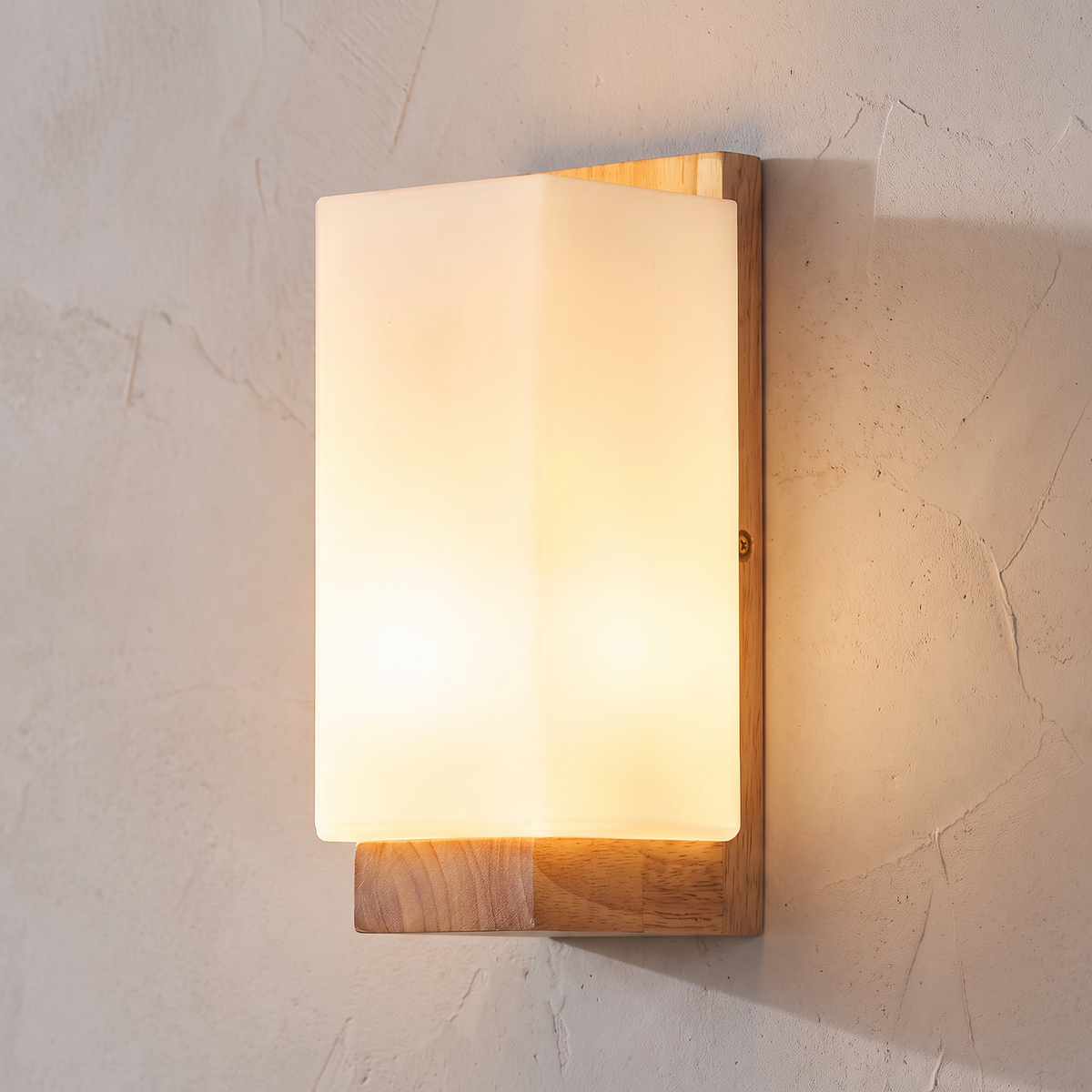 Close view of the Sofie sconce white glass framed by its wood plate and ledge