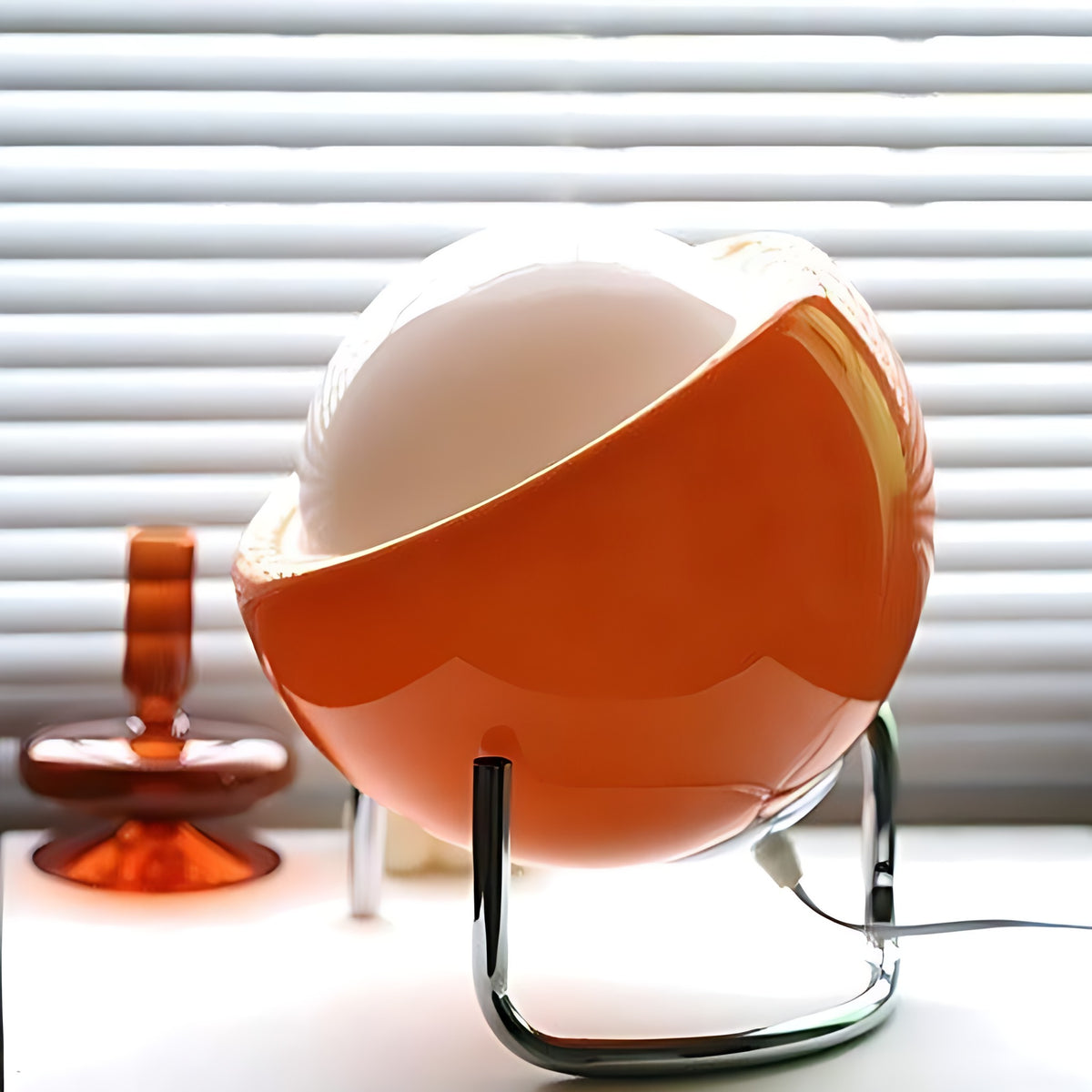 Solveig table lamp shown from the side with its two bent chrome legs