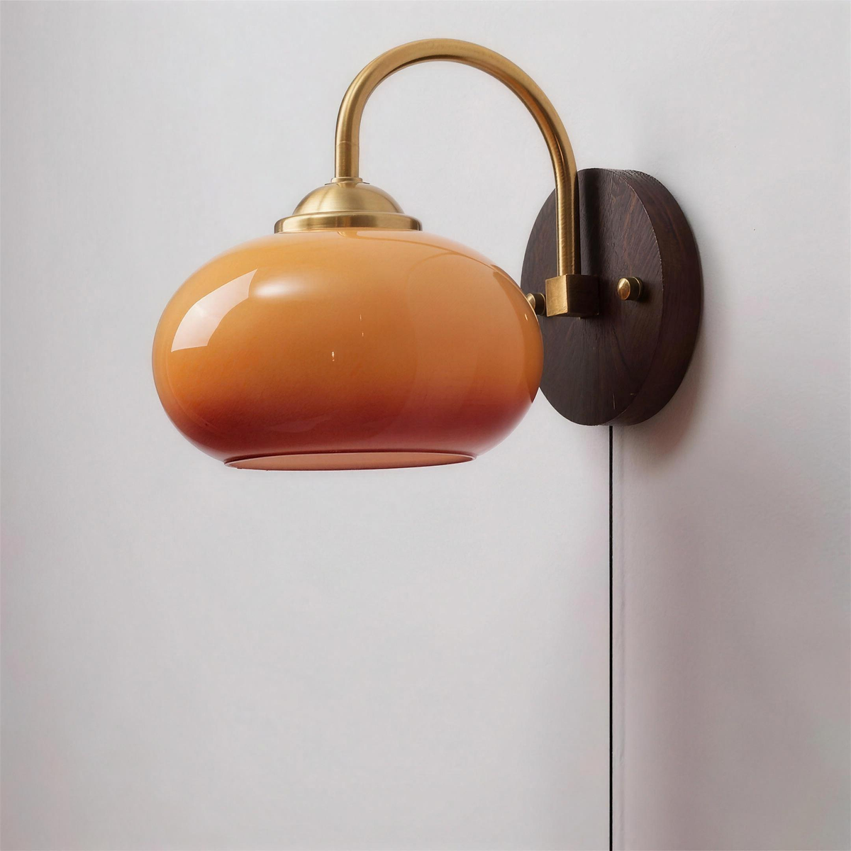 Stina wall sconce plug in version with its black cord, Oval Caramel shade