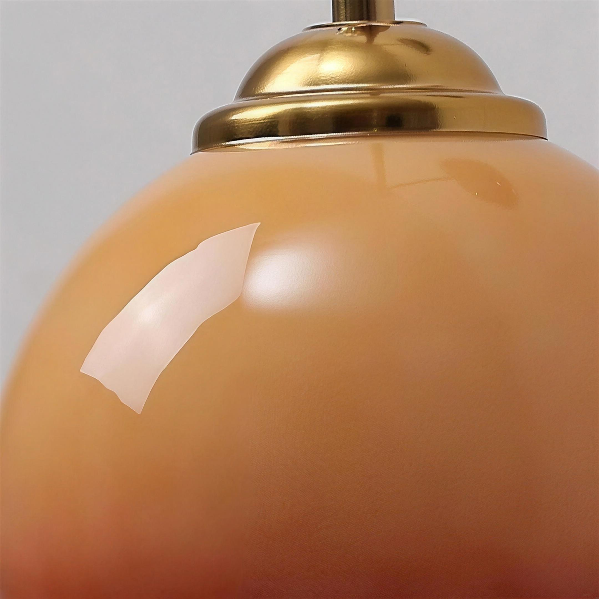 Close up of the caramel glass shade and brass tone cap