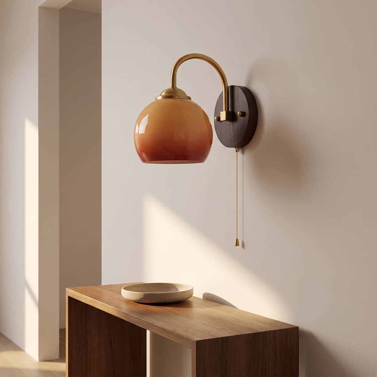 Stina wall sconce in Round Caramel on a hallway wall above a console