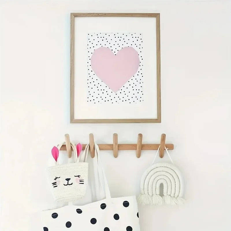 Stord peg rack under a framed print holding tote bags and a rainbow hanging