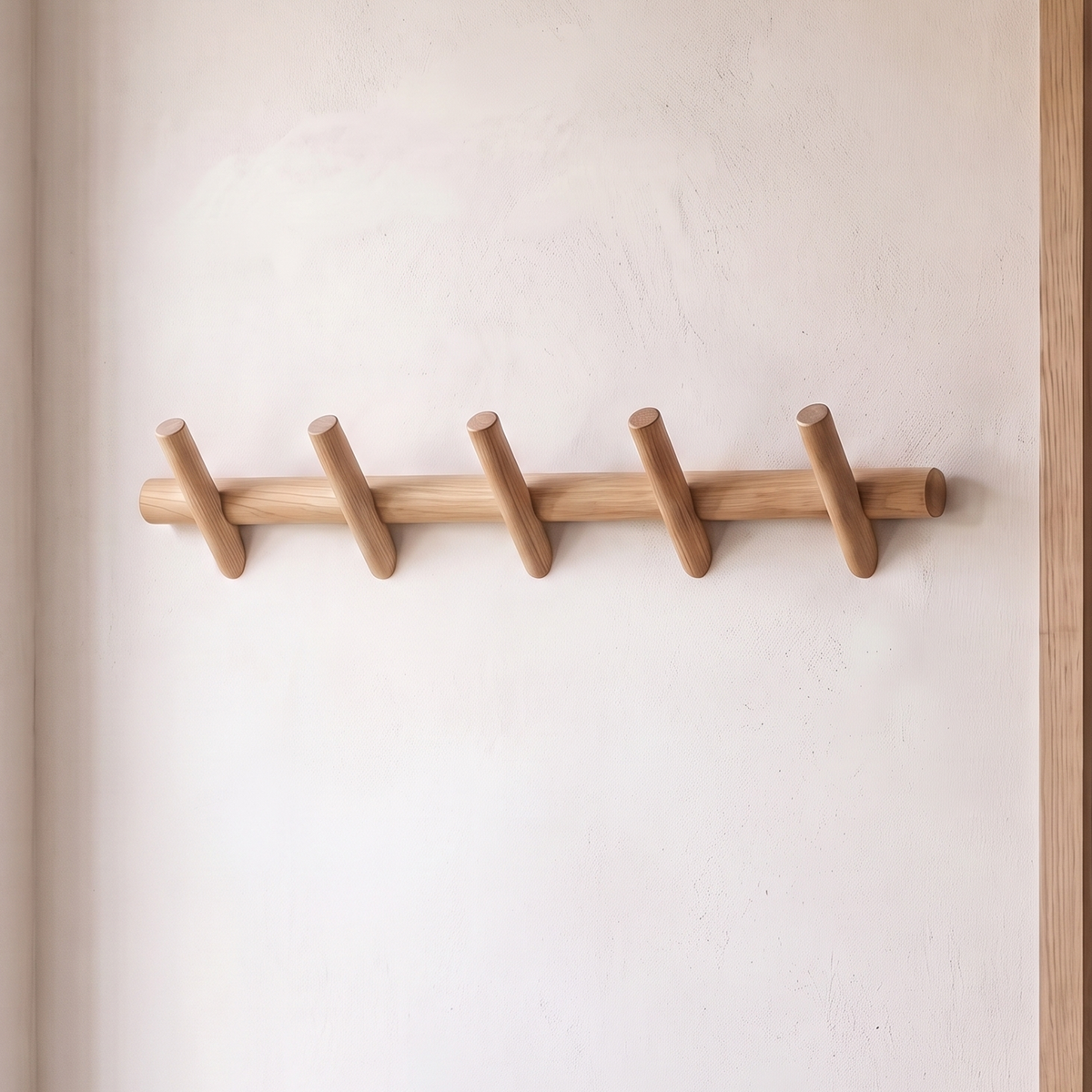 Stord solid oak peg rack with five angled pegs on a plaster wall