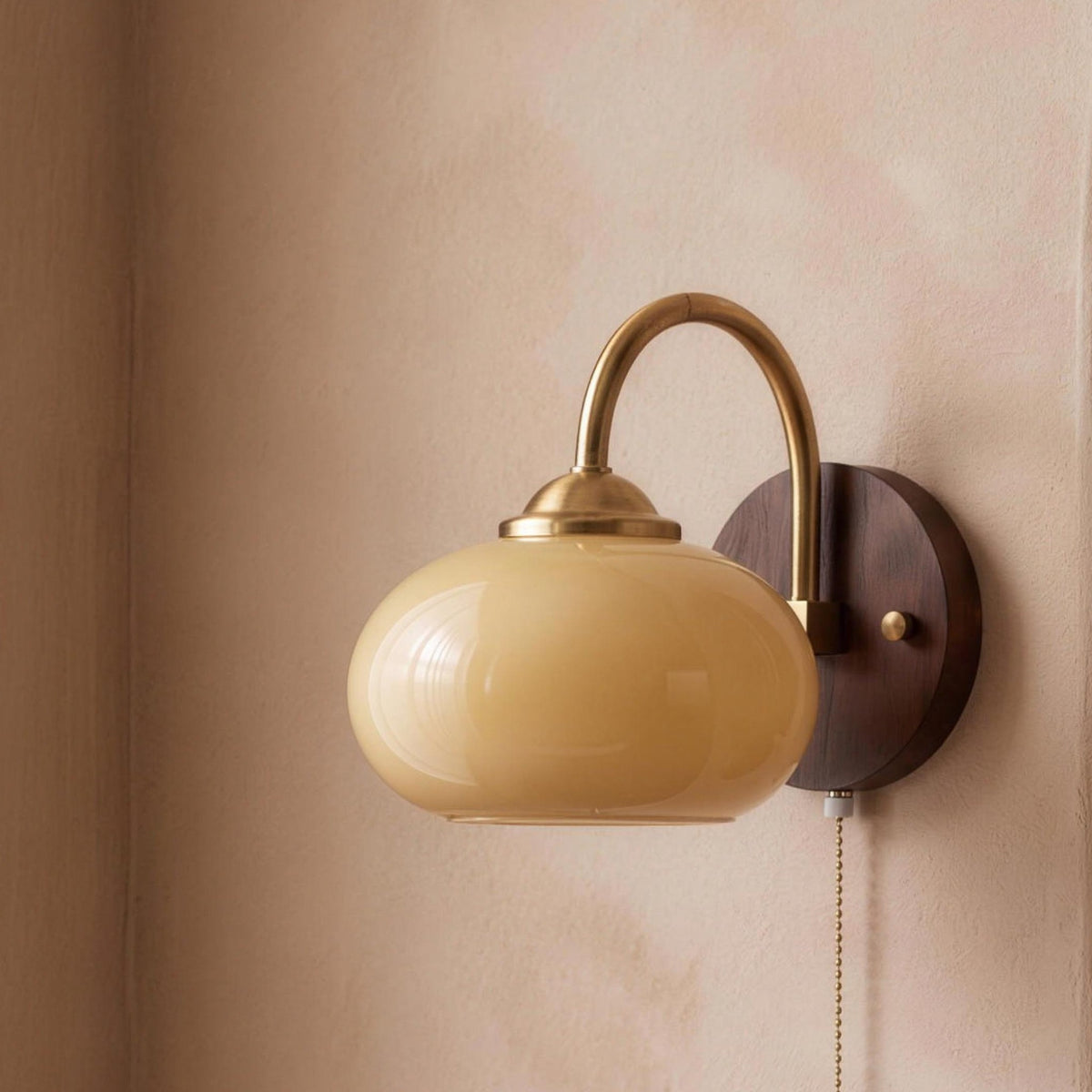Stina wall sconce in Oval Beige on a plaster wall