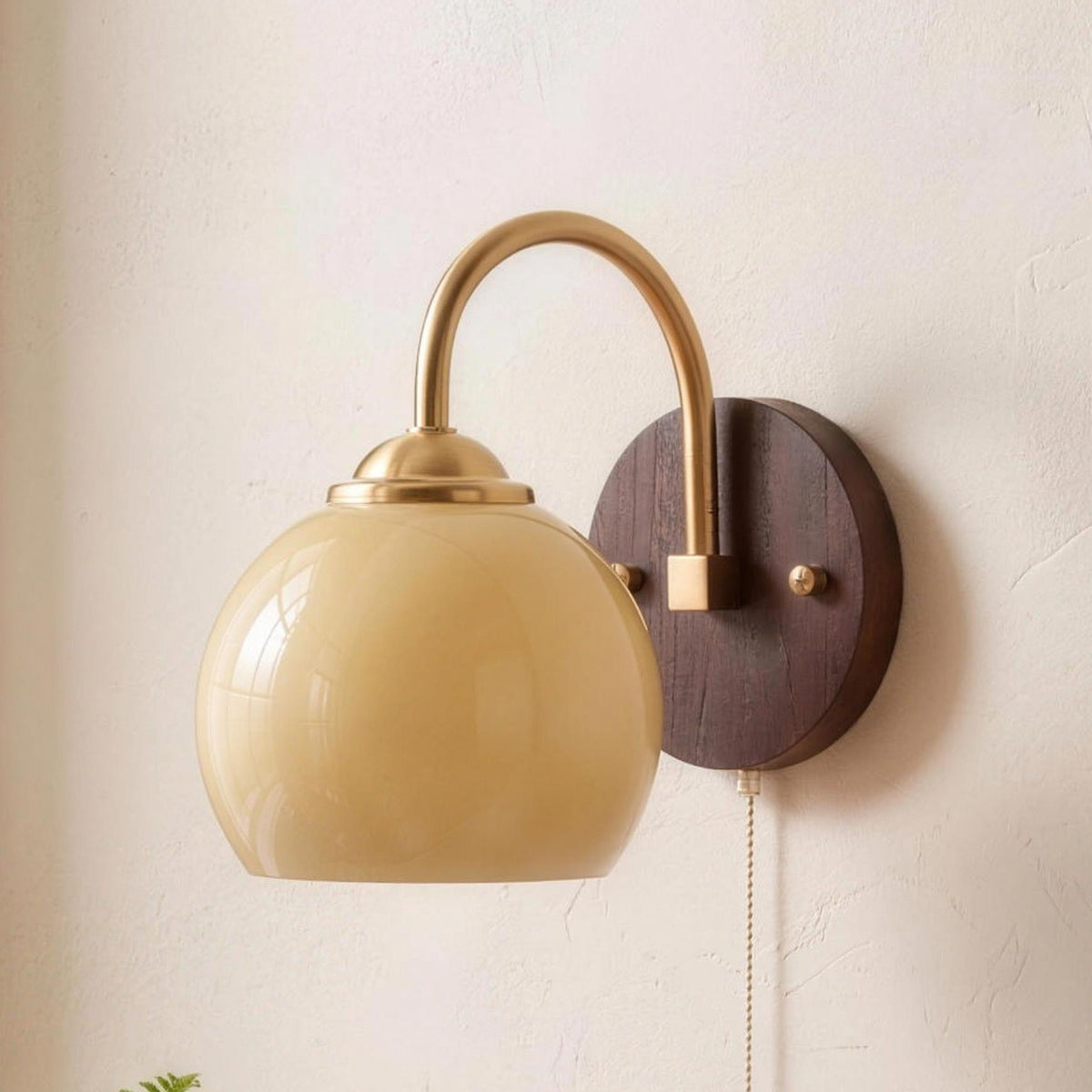 Stina wall sconce in Round Beige above a bedside