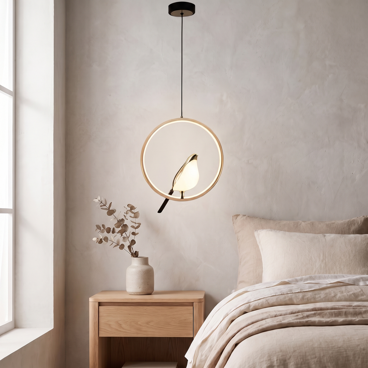 Tind bird pendant light, gold ring frame, above an oak nightstand