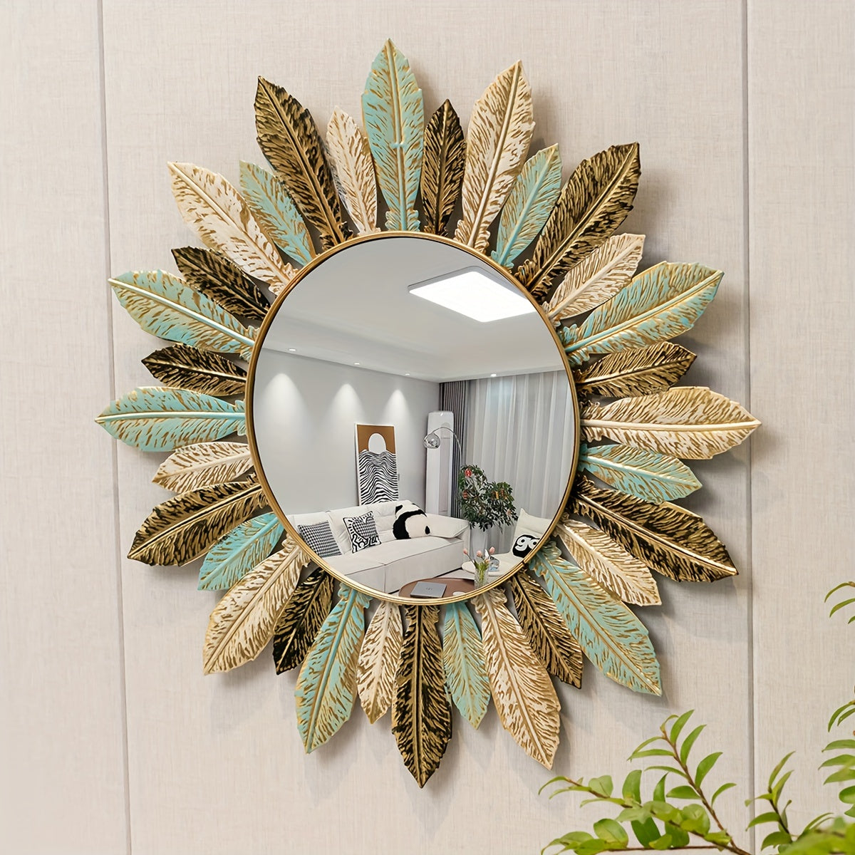 Tinn sunburst mirror with teal, gold and bronze leaves on a paneled wall