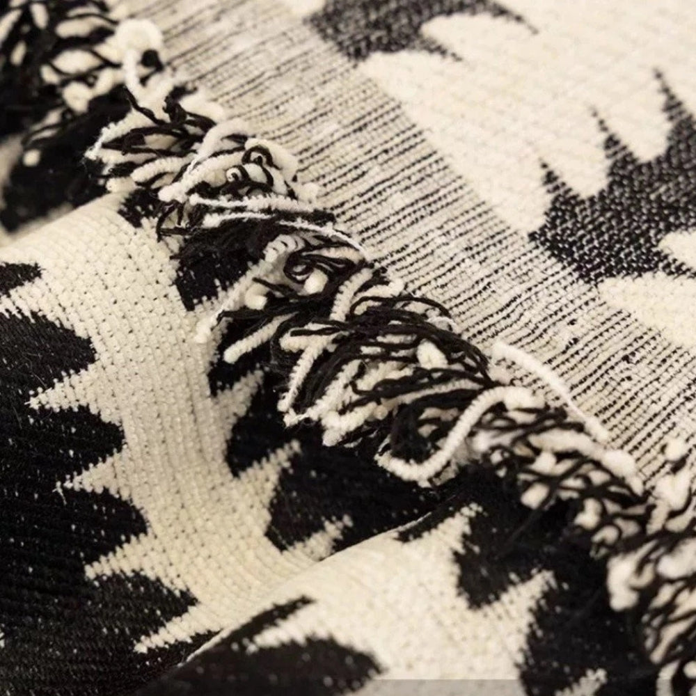 Close view of the tasseled end of the tufted sofa cover
