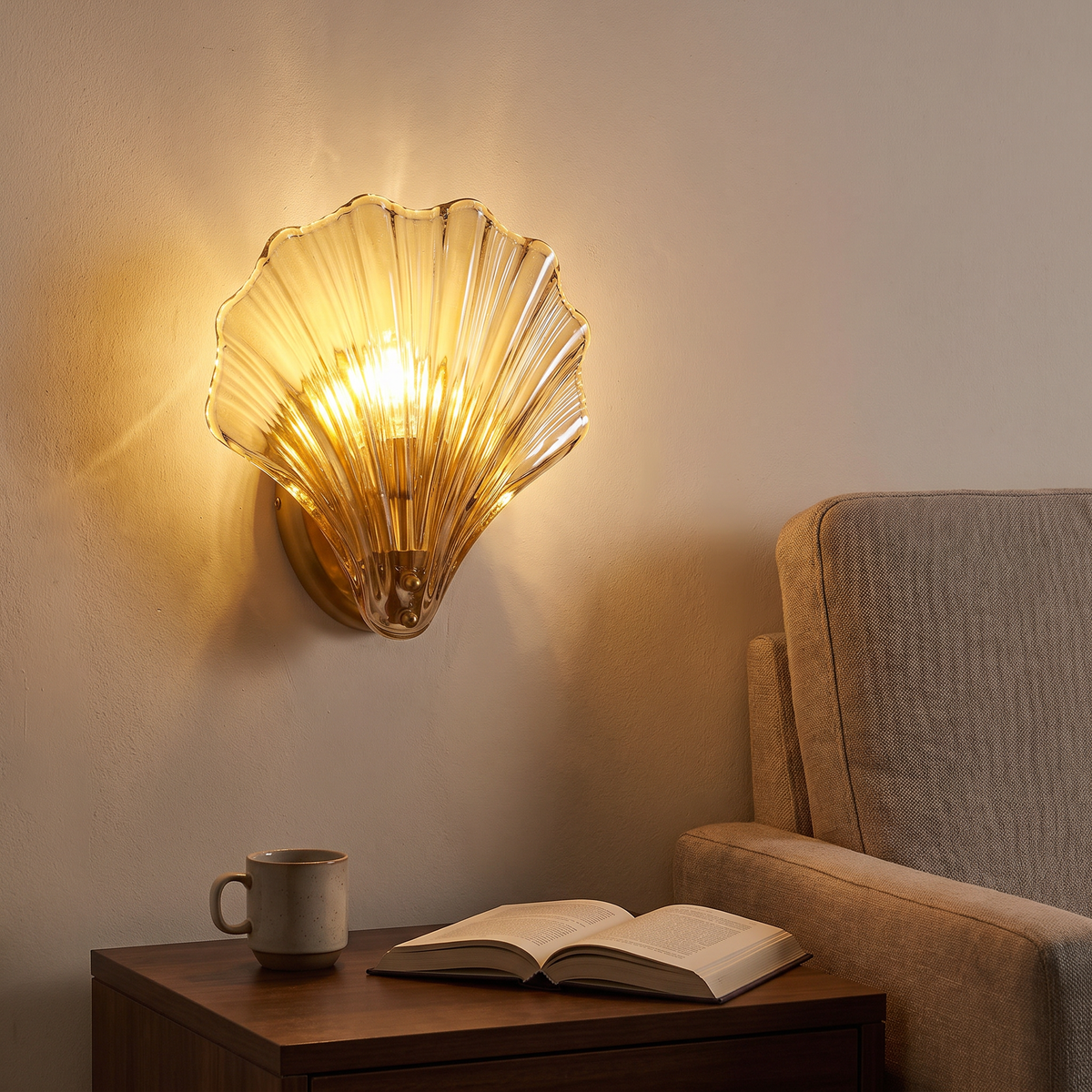 Tyra shell wall sconce above a side table and reading chair at night