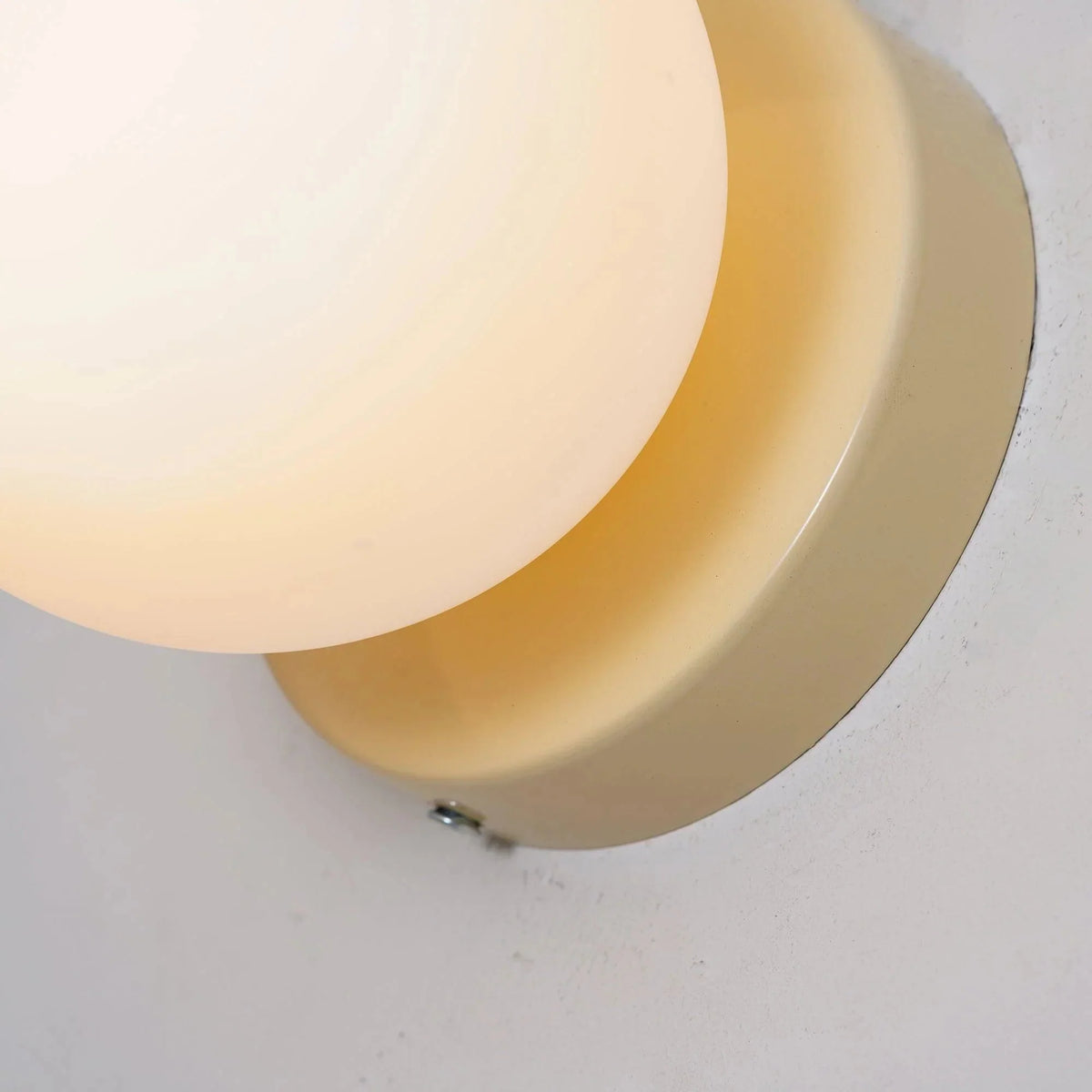 Close up of the lit white glass globe against its plate