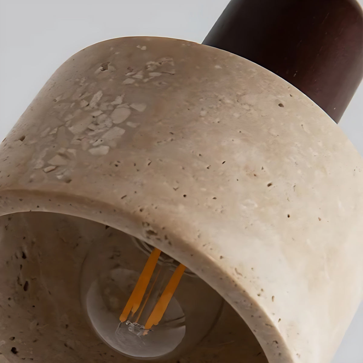 Close view of the travertine shade and bulb of the Vanja pendant light
