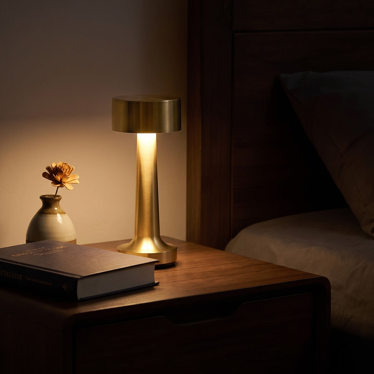 Venla table lamp in gold on a bedside table at night