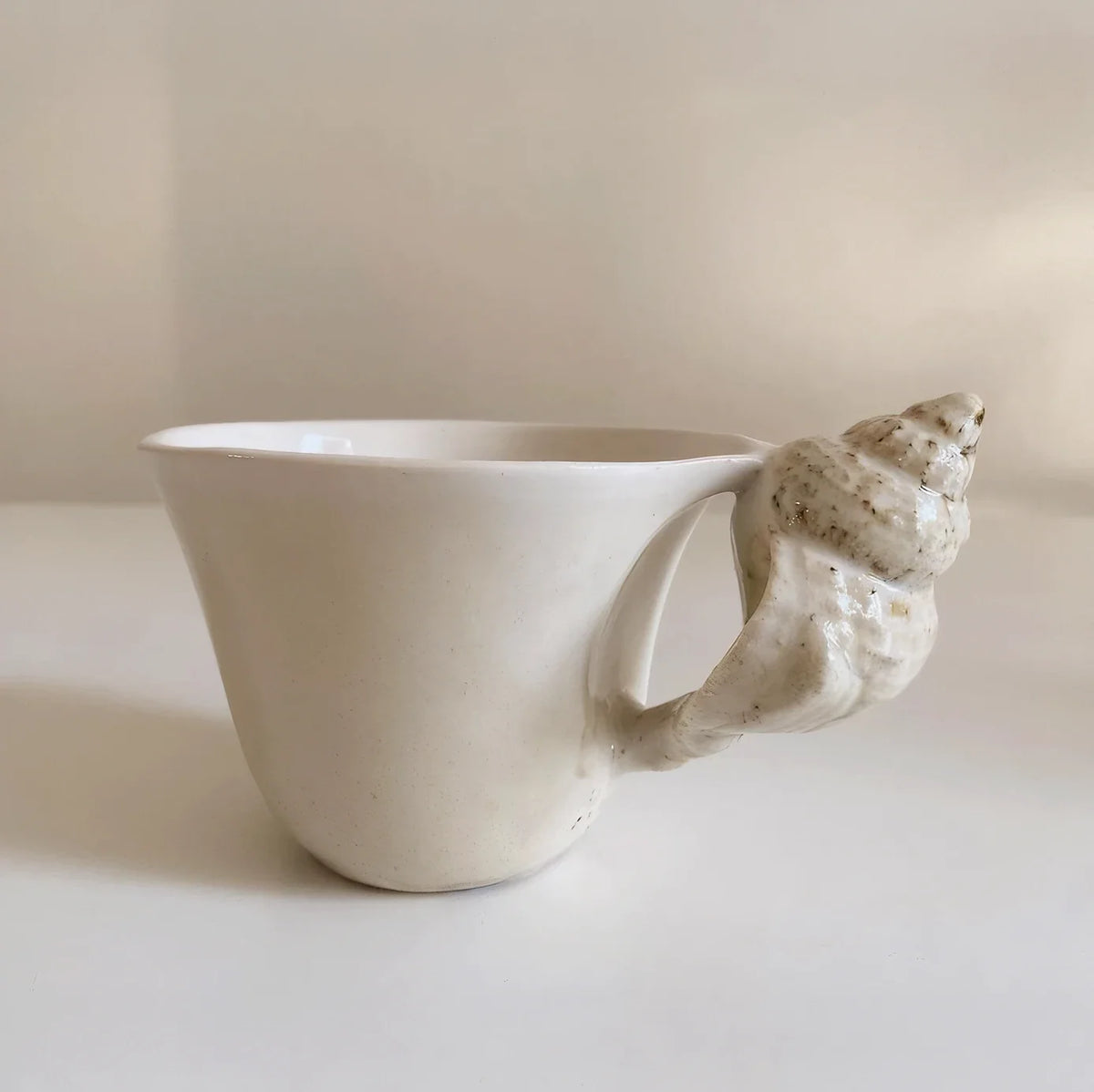 Side view of the cup showing the speckled conch shell handle