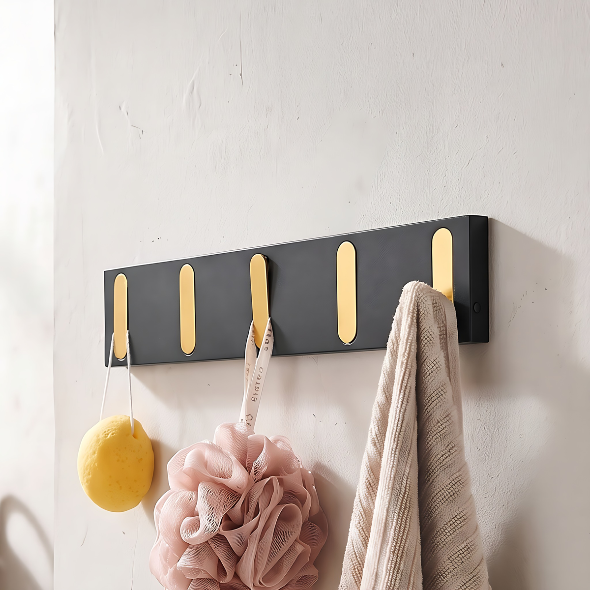 Wall hook rack with gold hooks, 5 hooks, 16.9", on a warm plaster wall