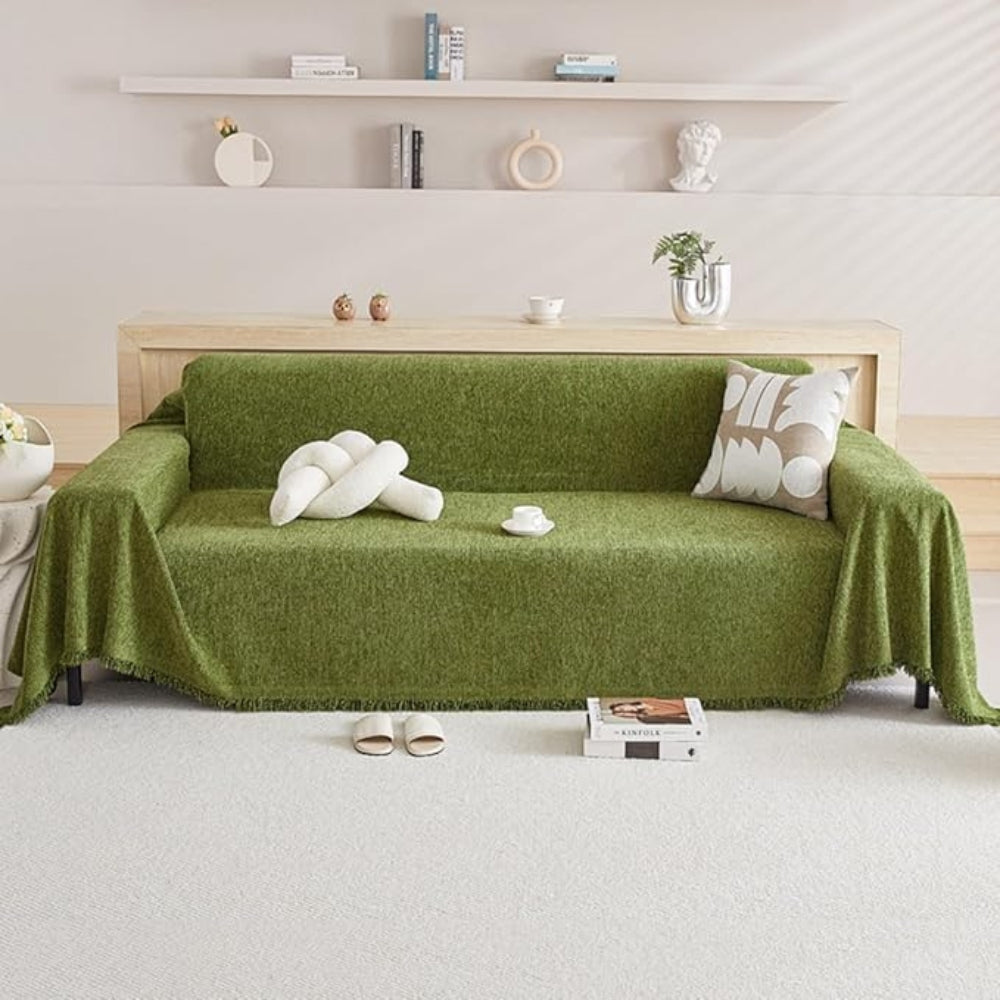 Green chenille couch cover over a whole three seat sofa seen from the front