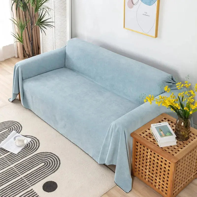 Light blue waterproof sofa cover over a sofa beside a side table