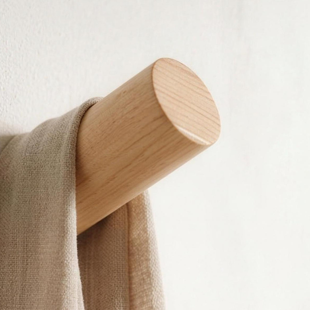 Small Angled wood wall peg in natural wood holding a linen scarf