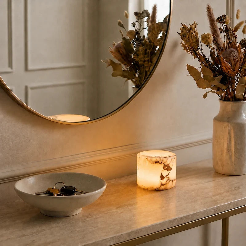 Ystad lamp glowing on a hallway console beside dried flowers