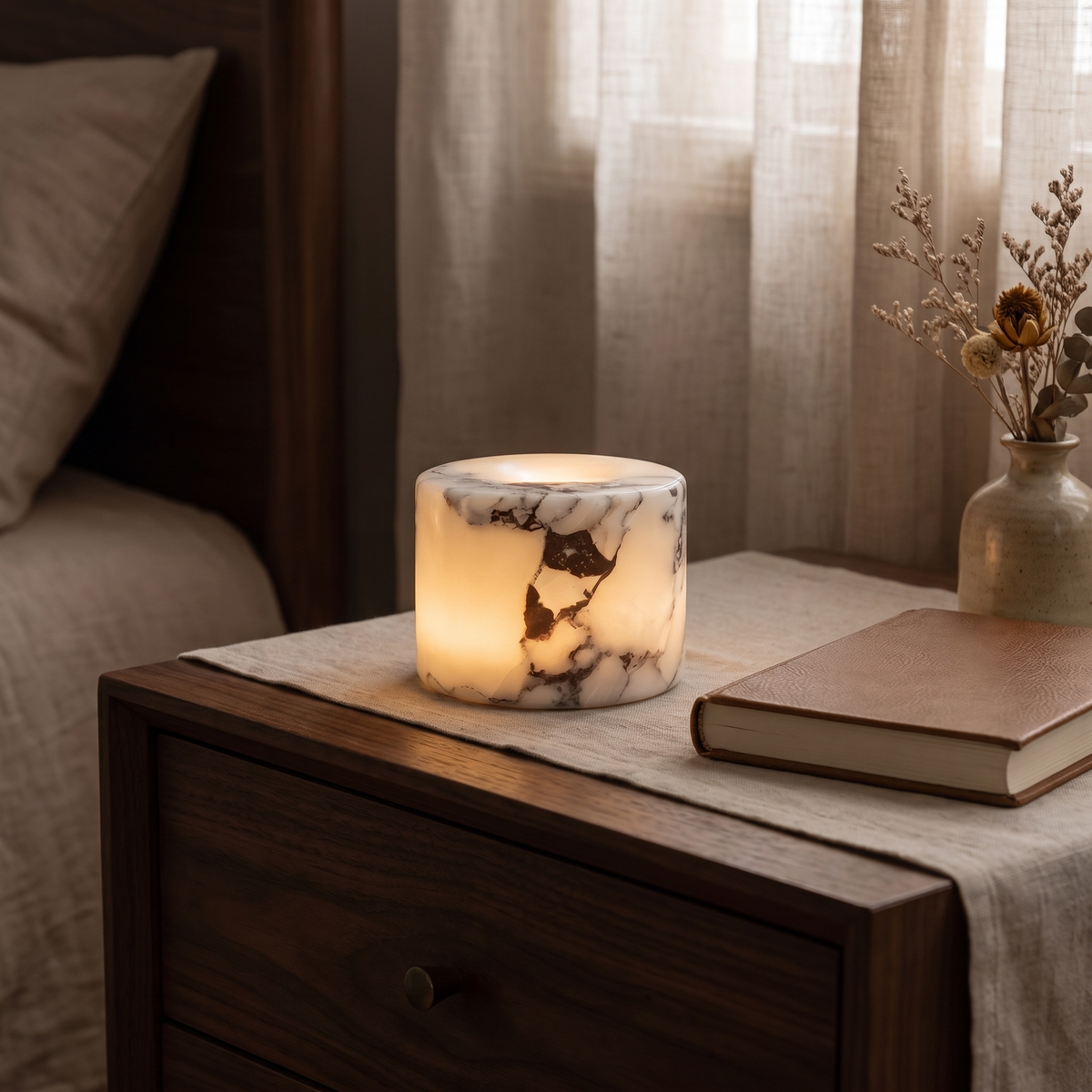 Ystad marble lamp glowing on a nightstand at night