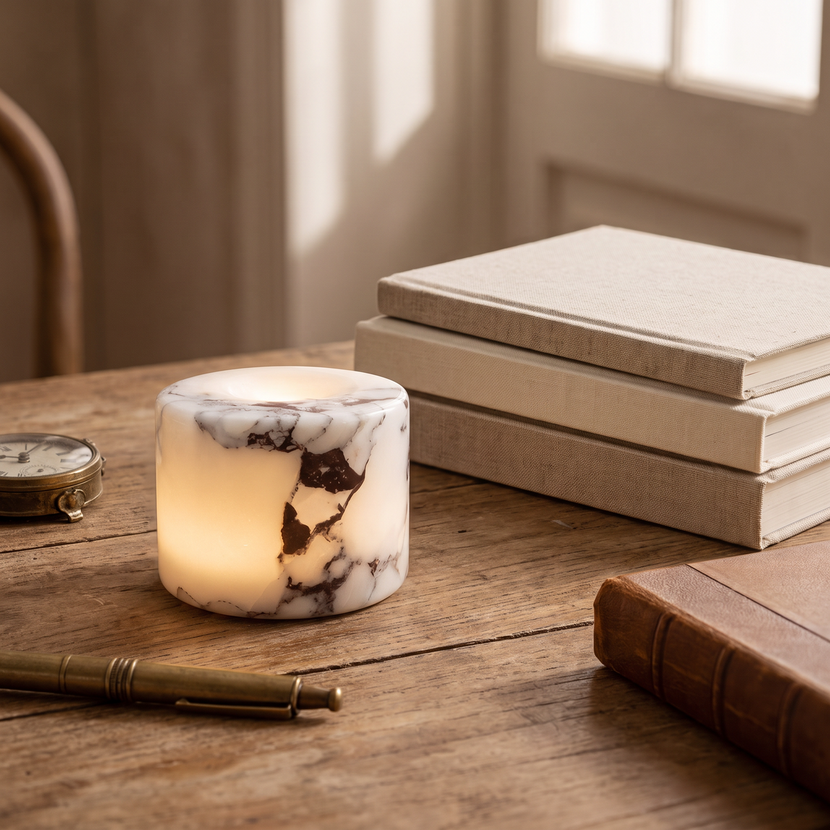 Ystad marble lamp on a wood desk beside linen notebooks